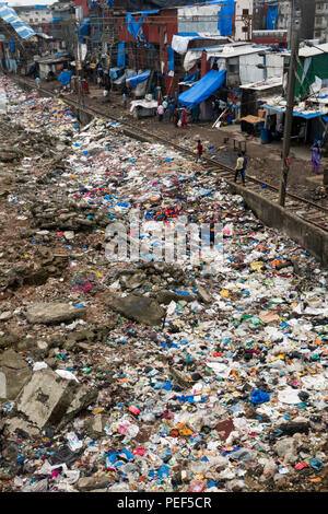 Piles of plastic trash next to train tracks and slum area at Bandra train station, Mumbai, India Stock Photo