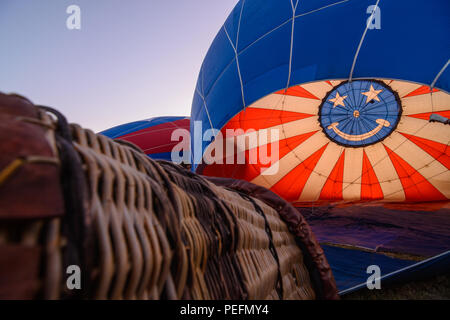 A hot air balloon and basket with a colorful smiley face being inflated just before the start of the Great Reno Balloon Race in 2017. Stock Photo