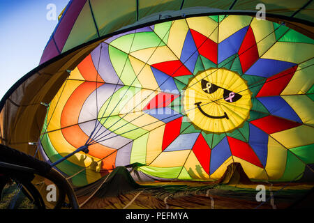 A hot air balloon with a colorful smiley face being inflated just before the start of the Great Reno Balloon Race in 2017. Stock Photo