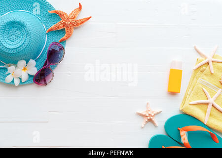 Beach accessories including sunglasses, starfish, hat beach, sunblock, colorful flip flop and shell on bright blue pastel wooden background for summer Stock Photo