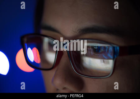 The image of computer screen in the glasess. Close up business woman wearing glasses working in the office on the laptop. Stock Photo