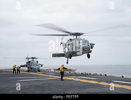 180814-N-XK809-1055 PACIFIC OCEAN (Aug. 14, 2018) An MH-60S Sea Hawk, assigned to the “Blackjacks” of Helicopter Sea Combat Squadron (HSC) 21, takes off from the flight deck of the amphibious assault ship USS Bonhomme Richard (LHD 6). Bonhomme Richard is currently underway in the U.S. 3rd Fleet area of operations. (U.S. Navy photo by Mass Communication Specialist 2nd Class William Sykes) Stock Photo