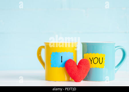 Coffee cups on wooden table with I LOVE YOU text and handmade red heart. Friendship day celebration background Stock Photo