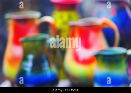 Some bright multi-colored earthenware jugs for water. Blurry Stock Photo