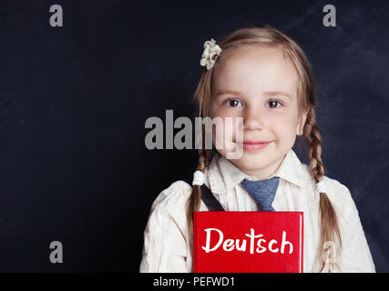 German concept with little schoolgirl student with pigtails hair. Smart kid learning german in language school Stock Photo