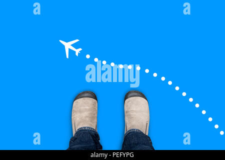 One in brown suede shoes standing on blue floor making a journey. A plane symbol flying from right to left. Stock Photo