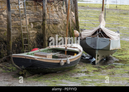old fashioned vintage wooden sailing dinghies, yachts or boats high and dry at low tide in bembridge harbour on the isle of wight. Stock Photo