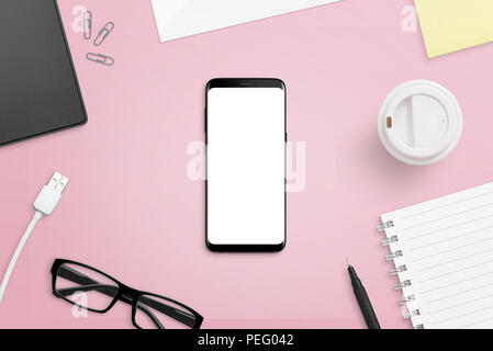 Mobile phone with isolated screen on pink, female desk. Phone with rounde edges mockup. Flat lay. Stock Photo