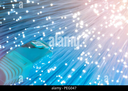Futuristic technological background, closeup on the end of optical fiber network cable on blue and cream background. Shallow DOF, partial focus on the Stock Photo