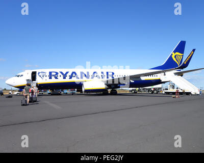 Passengers walking across the tarmac towards their homeward flight on a Ryanair plane Stock Photo