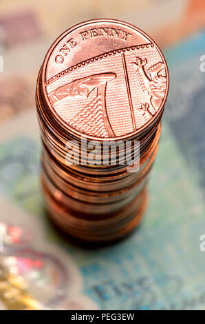 Pile of British pennies on banknotes Stock Photo