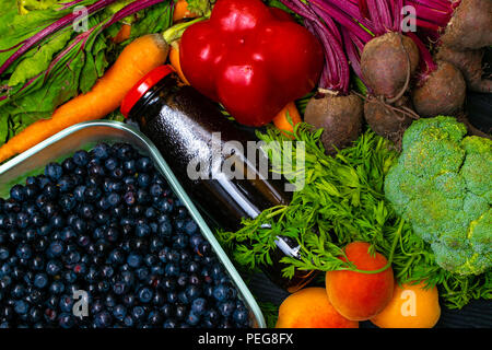 vitamin A in vegetable food, carrot, beet, pomegranate juice, pepper, apricot,broccoli, blueberry in wooden background. Detox Stock Photo
