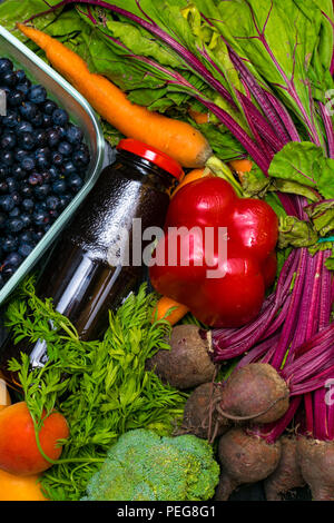 vitamin A in vegetable food, carrot, beet, pomegranate juice, pepper, apricot,broccoli, blueberry in wooden background. Detox Stock Photo