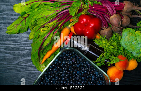 vitamin A in vegetable food, carrot, beet, pomegranate juice, pepper, apricot,broccoli, blueberry in wooden background. Detox Stock Photo