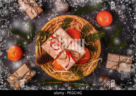Christmas composition with tangerines, gift boxes, cones on dark  background. Stock Photo
