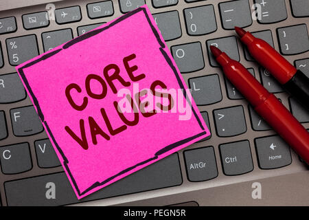 Text sign showing Core Values. Conceptual photo belief person or organization views as being importance Pink paper keyboard Inspiration communicate id Stock Photo