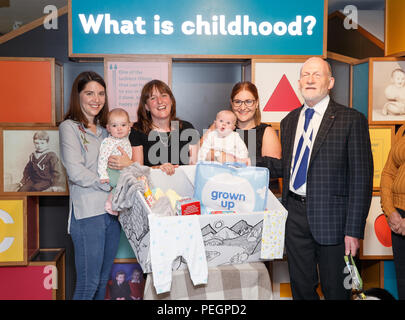 Maree Todd (third left), Minister for Children and Young People, with (left to right) Sarah Morrison and daughter Chrissie, Gillian Steele with daughter Erin and Councillor Derek Howie, marks the first anniversary of the Baby Box initiative at the Museum of Childhood, as one of the boxes is to be preserved in history as an exhibit at the Edinburgh attraction. Stock Photo