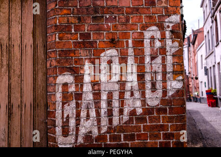 Landscape view of one of the streets of Bruges in Belgium, with a Garage sign painted on a brick wall in the foreground Stock Photo