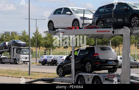 Schoenefeld, Germany. 15th Aug, 2018. Unauthorised Volkswagen vehicles are unloaded by car transporters at a parking lot at BER Airport in Schoenefeld near Berlin, which has not yet been opened, and then parked in a nearby multi-storey car park. VW has rented around 8,000 parking spaces in three multi-storey car parks and three open spaces at the terminal. Credit: Wolfgang Kumm/dpa/Alamy Live News Stock Photo