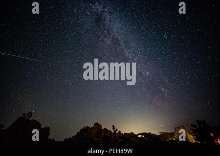 Joshua Tree, California, USA. 13th Aug, 2018. 2018 Perseid meteor shower at Joshua Tree National Park with Milky Way visible and glow on the horizon. Credit: Stan Sholik/ZUMA Wire/Alamy Live News Stock Photo