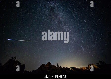 Joshua Tree, California, USA. 13th Aug, 2018. 2018 Perseid meteor shower at Joshua Tree National Park with Milky Way visible and glow on the horizon. Credit: Stan Sholik/ZUMA Wire/Alamy Live News Stock Photo