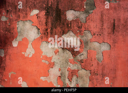Old Red crumbled painted cement wall for background Stock Photo