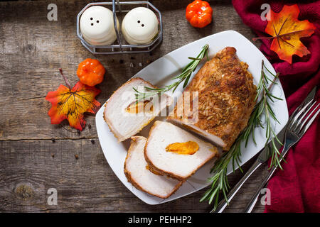 Meat roll (roulade) with with apricot stuffing and spices on a kitchen wooden table. Thanksgiving day appetizer. Top view flat lay background Stock Photo