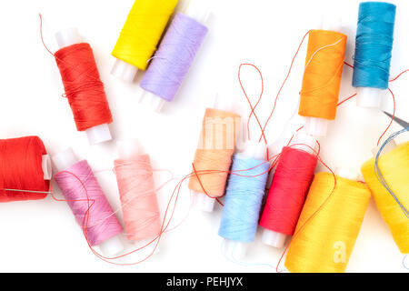 Overhead photo of thread spools of various colors on white with copy space Stock Photo
