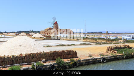 Windmills raising water and flats in which water is evaporated to obtain salt in salines near Trapani, Sicily, Italy Stock Photo