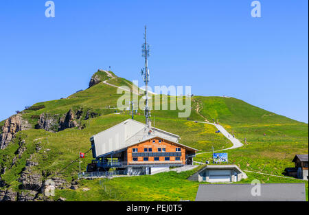 Maennlichen cable car station above Wengen in the Jungfrau region and walking path to the Royal View, Bernese Oberland Switzerland with clear blue sky Stock Photo