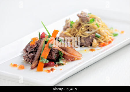 Peruvian dish called Lomo Saltado made of tomato, beef meat and onions mixed with French fries. Stock Photo