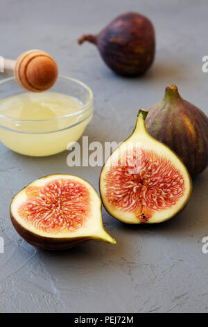 Fresh figs with honey on gray background, side view. Close-up. Stock Photo