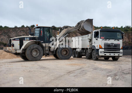 Fine aggregate is poured into a truck for distribution at Whitwell Quarry, Derbyshire UK Stock Photo