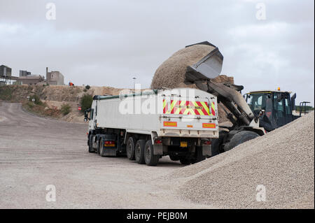Fine aggregate is poured into a truck for distribution at Whitwell Quarry, Derbyshire UK Stock Photo