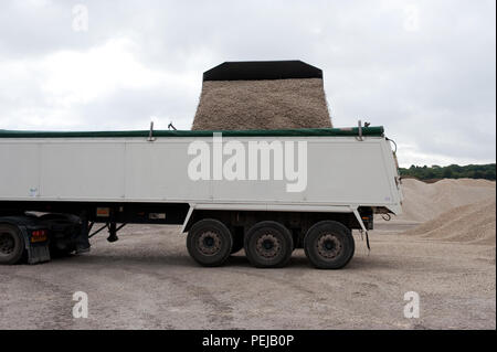 Fine aggregate is poured into a truck for distribution at Whitwell Quarry, Derbyshire UK Stock Photo