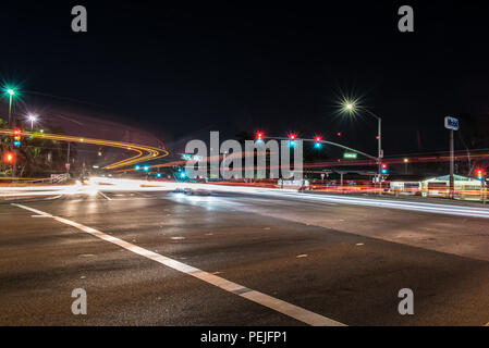 Intersection of Mills Road and East Main Street showing streaking headlights and bright lamps in early hours of a busy morning on August 15, 2018 in V Stock Photo