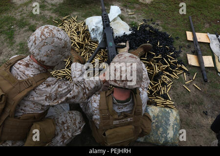 Lt. Col. Jeremy S. Winters, left, and Gunnery Sgt. Clifford Bowen reload a Browning M2 .50-caliber machine gun during a weapons familiarization range at Marine Corps Base Camp Lejeune, North Carolina, Aug. 27, 2015. More than 100 Marines from Marine Air Support Squadron 1 honed their weapons skills with the M240B machinegun, Browning M2 .50 caliber machine gun and the M1014 combat shotgun. Marines from various military job occupations received hands-on experience that allows them to improve crucial skills and become well-rounded war fighters. (U.S. Marine Corps photo by Cpl. N.W. Huertas/ Rele Stock Photo