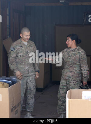 Spc. George A. Ruiz, a human resources specialist with the 49th Personnel Company, Resolute Support Special Troops Battalion, 1st Armored Division Resolute Support Sustainment Brigade, 13th Sustainment Command (Expeditionary), shows his company commander, Maj. Manju Vig, how they store outgoing mail before it is shipped on Herat, Afghanistan, Aug. 9, 2015. Vig was verifying that there were enough security measures in place and checking on how her Soldiers at Herat were doing. (U.S. Army photo by Sgt. Adam Hinman 1st Armored Division Resolute Support Sustainment Brigade, 13th Sustainment Comman Stock Photo