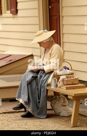 Woman reenactor sewing in Colonial Williamsburg, Virginia, USA Stock Photo