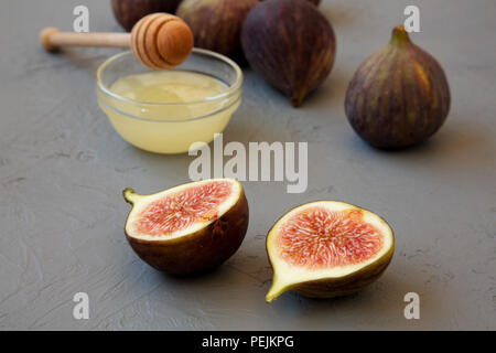 Fresh figs with honey on gray surface, side view. Closeup. Stock Photo