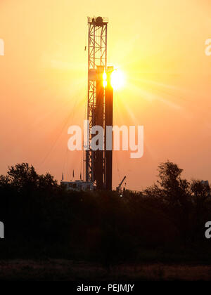 Sun rises over a petroleum well, taken in North Texas in the Barnett Shale Field. Fossil fuel is a growing crisis as the world  refuses to slow down. Stock Photo