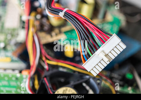 Connector with power cables for computer mainboard. Colorful blurry background of PC components. Electronics industry, sorting and disposal of e-waste. Stock Photo