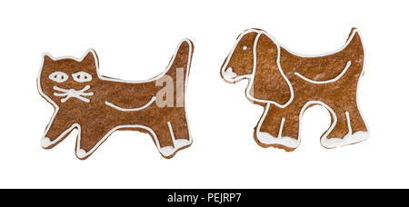 Cute Christmas gingerbreads in cat and dog shape. Two sweet fragrant candies decorated by icing. Traditional confections. Idea of Xmas, Children's day. Stock Photo