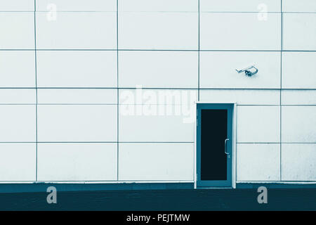 wall of the building, the door and the CCTV camera. Security. Blue background. Stock Photo