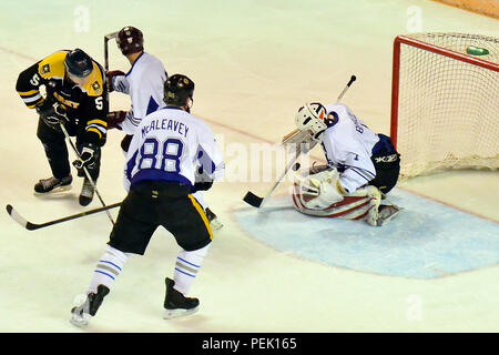 Air Force goalie Senior Airman Stanislov Barilov blocks a shot from Army's Staff Sgt. Kris Olson in the 21st Annual Army vs Air Force hockey game Saturday, Dec. 5, at the Carlson Center in Fairbanks, Alaska. Air Force held on to win the game 4-2. (U.S. Army photo/John Pennell) Stock Photo