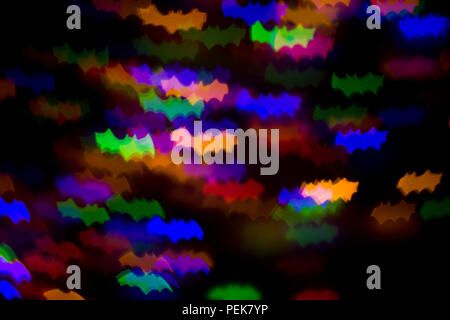 defocused bokeh multicolor lights in shape of bats for halloween background - holidays, decoration and party concept Stock Photo