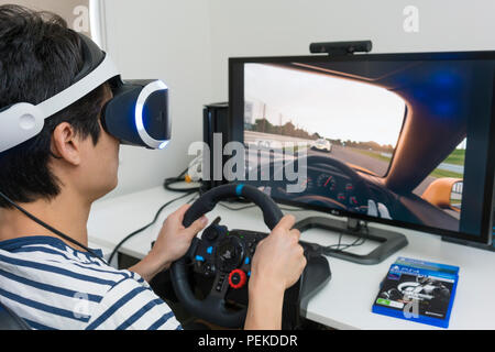 Playing racing video game with VR headset at home Stock Photo