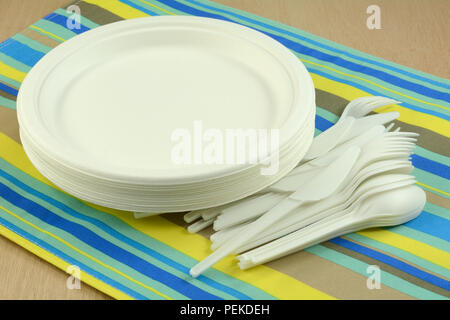 White eco-friendly disposable compostable plates and cutlery made from sugar cane fiber on place mat Stock Photo