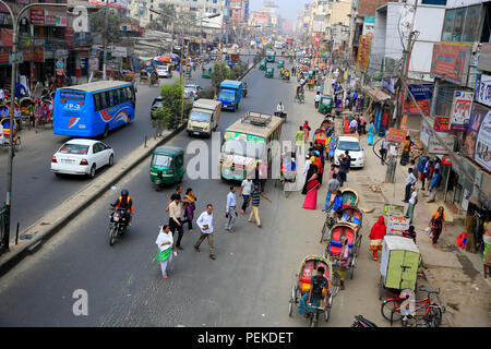 Pedestrians cross a busy road putting their lives at risk. Dhaka, Bangladesh Stock Photo