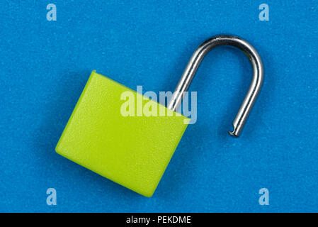 Green padlock isolated on blue background Stock Photo
